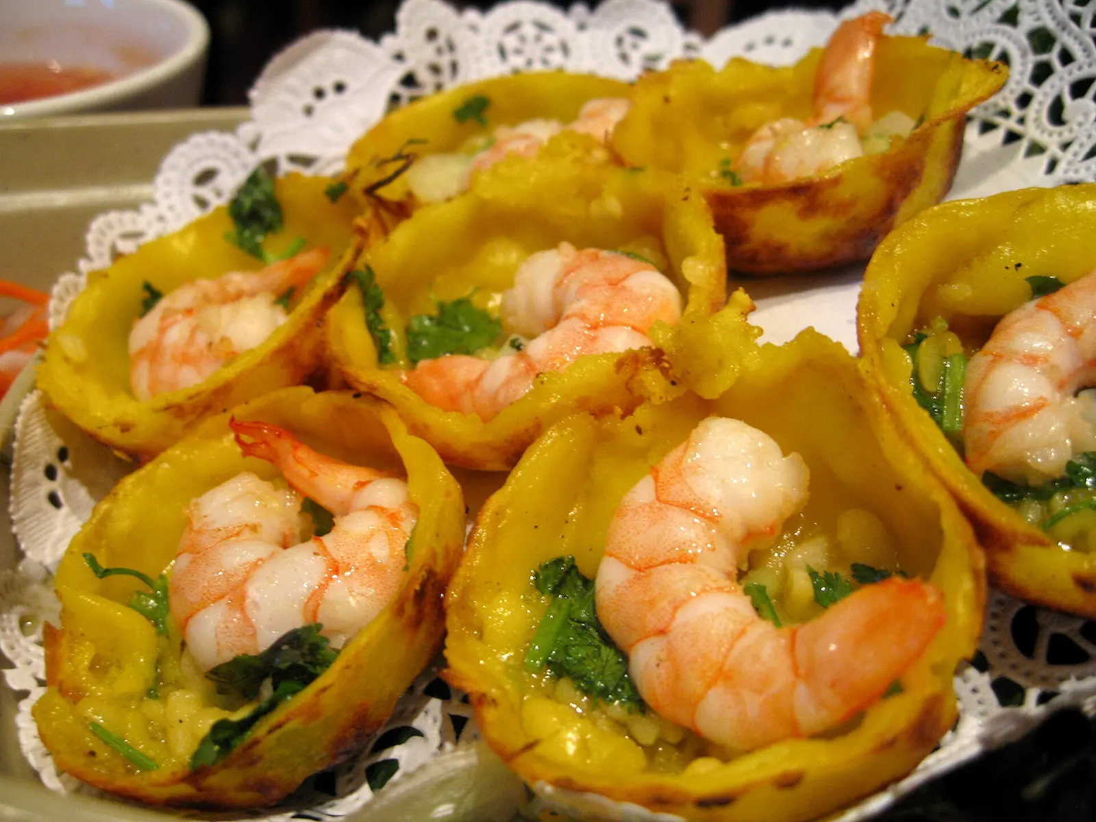 Close-up of bánh khọt: small crispy rice cakes topped with shrimp