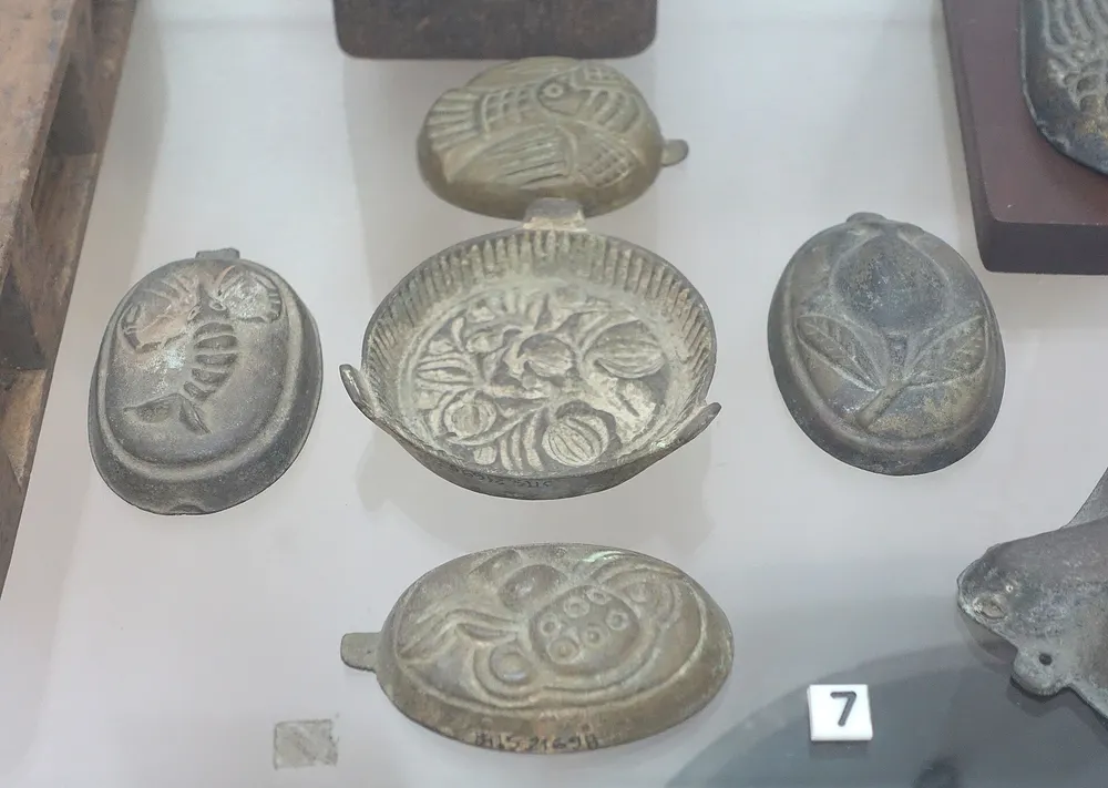 Old metal cake moulds on display in the Museum of Vietnamese History, Ho Chi Minh City