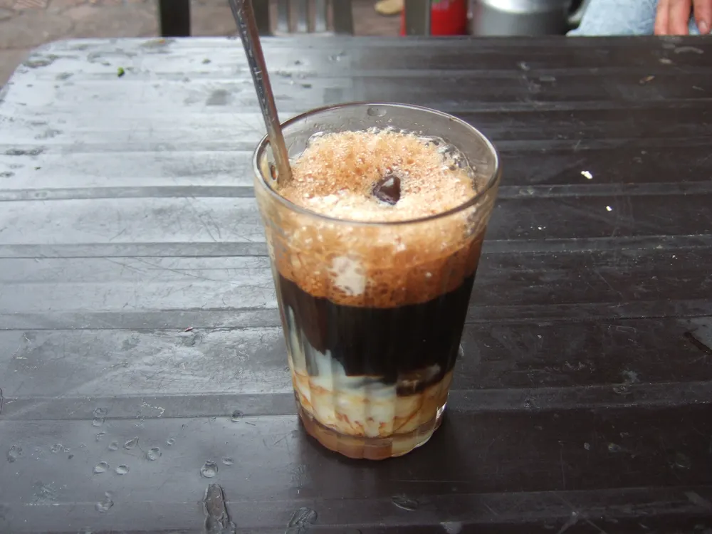 Glass of Vietnamese milk coffee on a wooden table