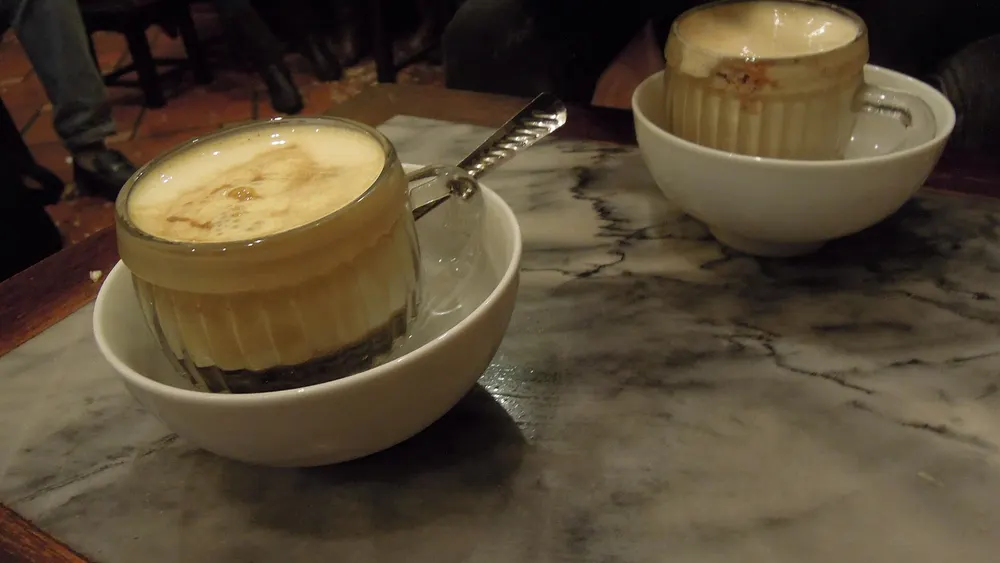 Two cups of egg coffee with a thick creamy top