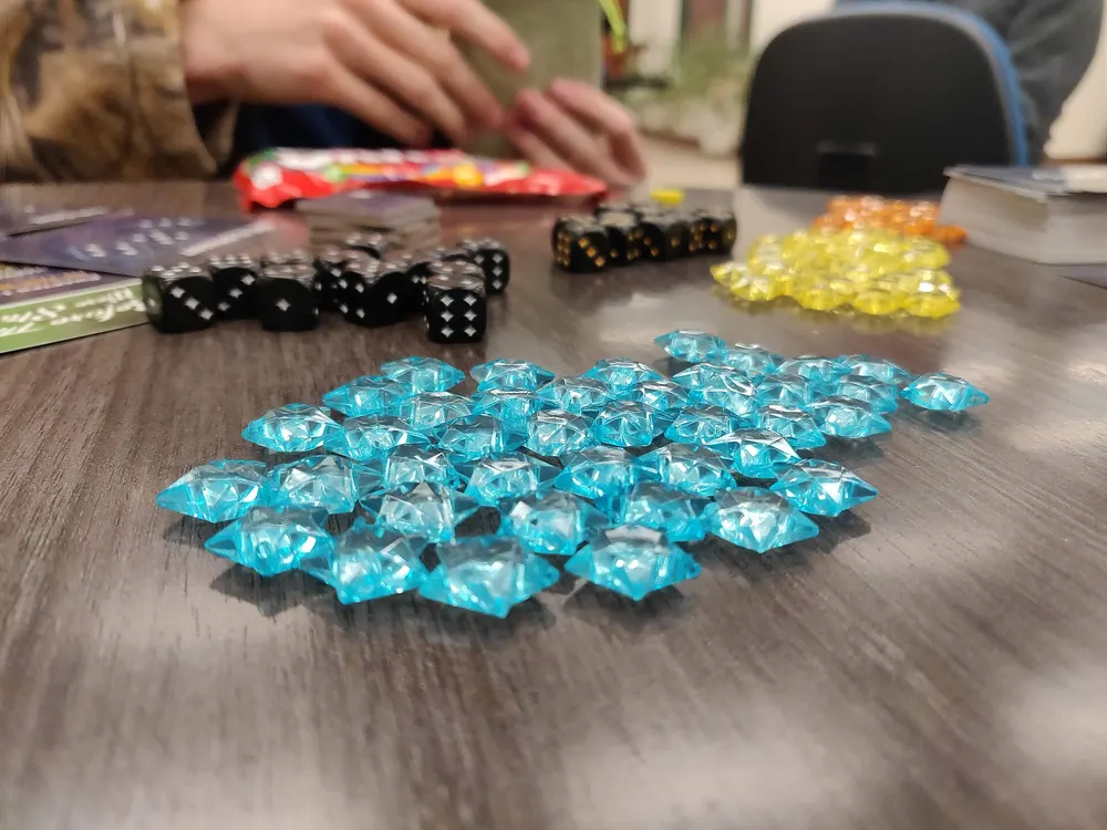 Blue plastic game pieces and dice spread on a table