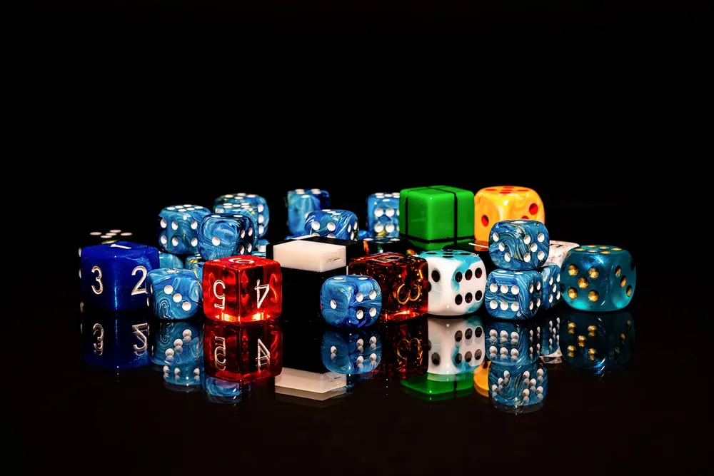 Assorted coloured dice on a black surface