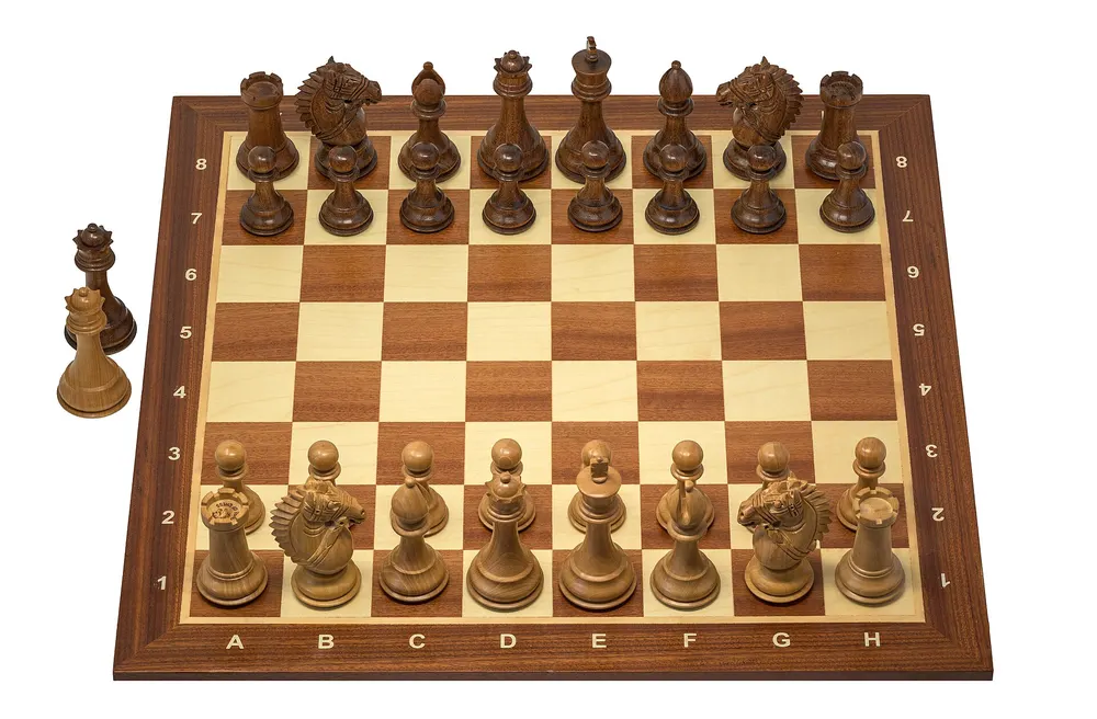 Wooden chess set with all pieces lined up on the board