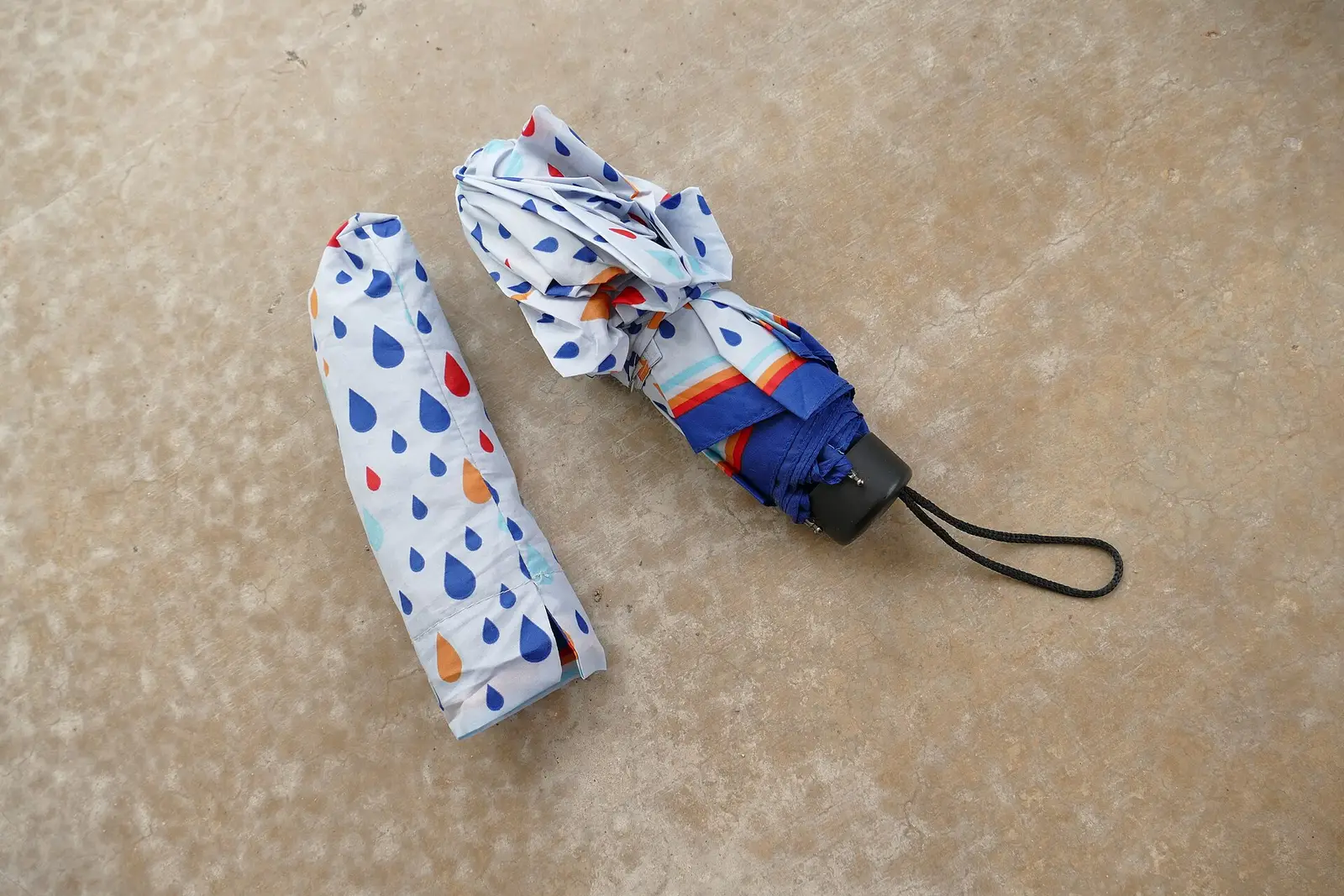 Folded umbrella next to its case