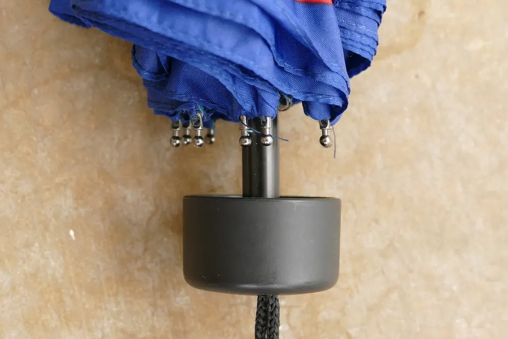 Close-up of a partly closed folding umbrella and its handle