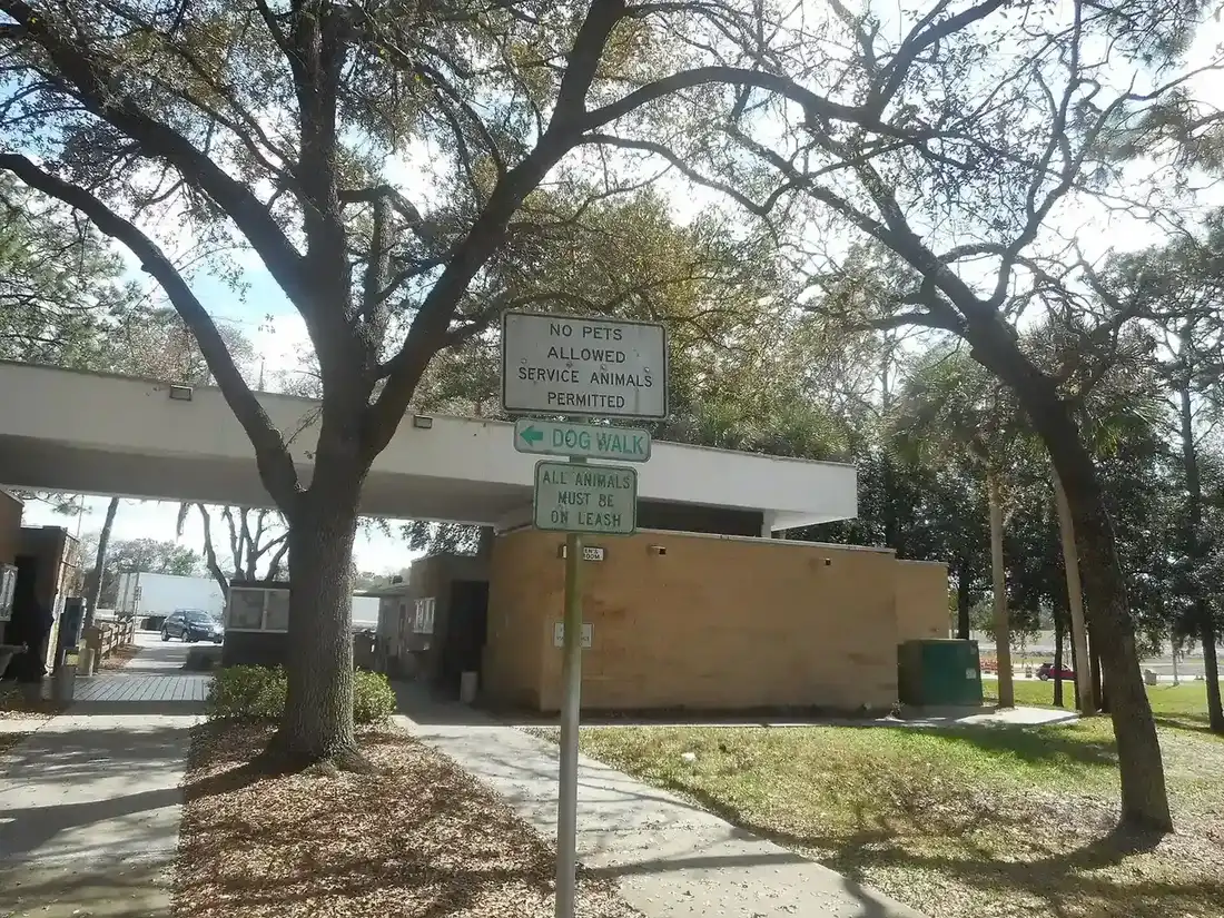 Dog-walk area sign under trees at a rest stop
