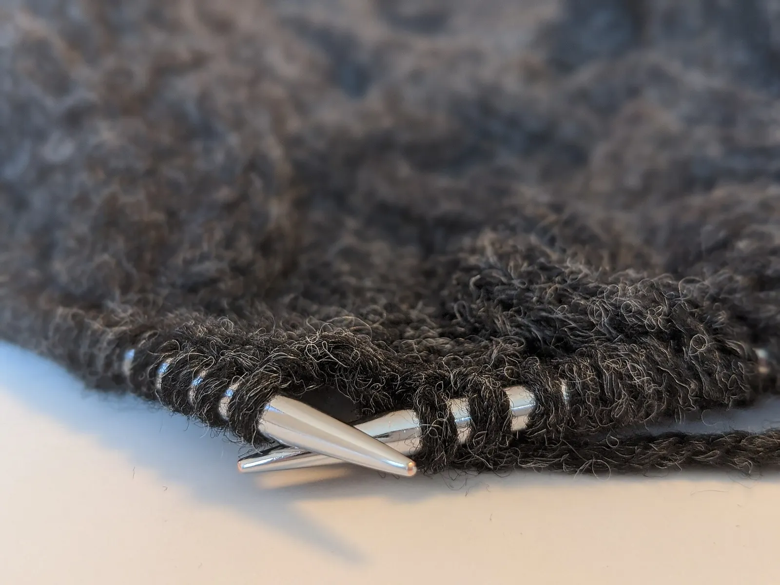 Knitting needles in dark wool