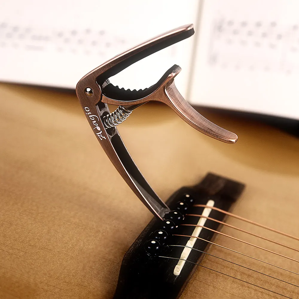 Guitar capo clipped next to the strings and pegs