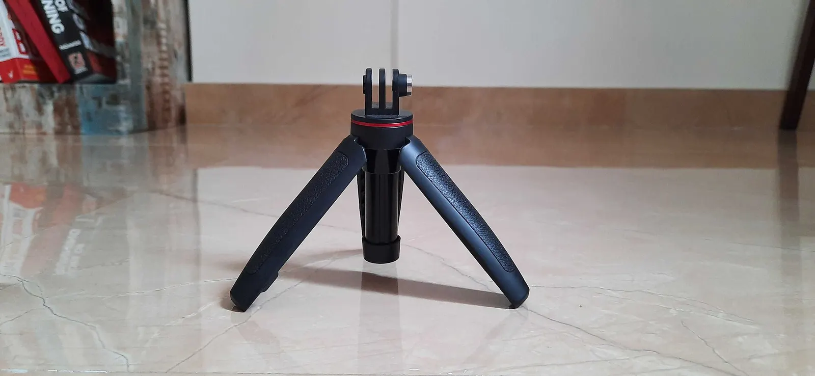 Small mini tripod standing on a tiled floor