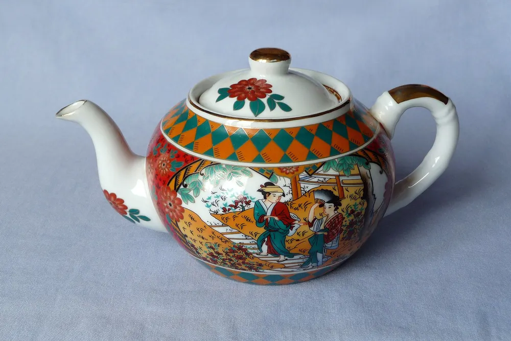 White teapot with a red and green floral pattern